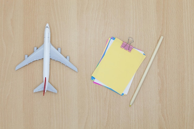 Foto diretamente acima do clipboard por avião de brinquedo e lápis em mesa de madeira