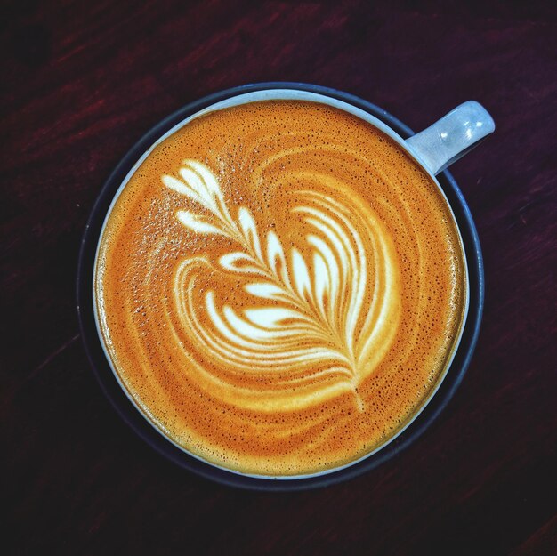 Foto diretamente acima do copo de cappuccino servido na mesa