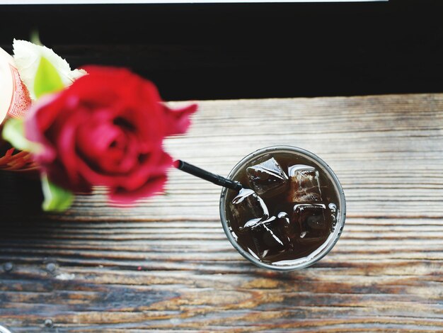 Foto diretamente acima do shot de cola servido em uma mesa de madeira