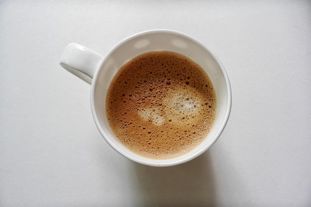 Diretamente acima do tiro da xícara de café na mesa