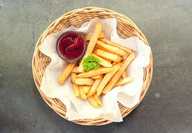 Diretamente acima do tiro de batatas fritas com ketchup em cesta de vime
