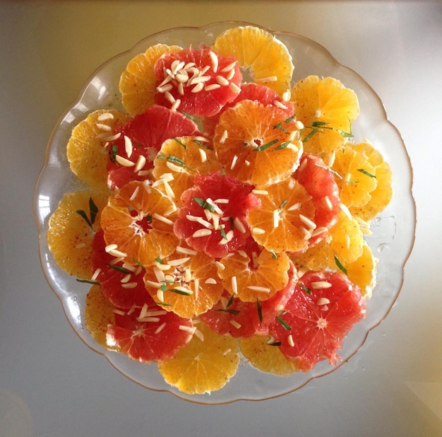 Foto diretamente acima do tiro de fatias de laranja servidas em uma tigela na mesa