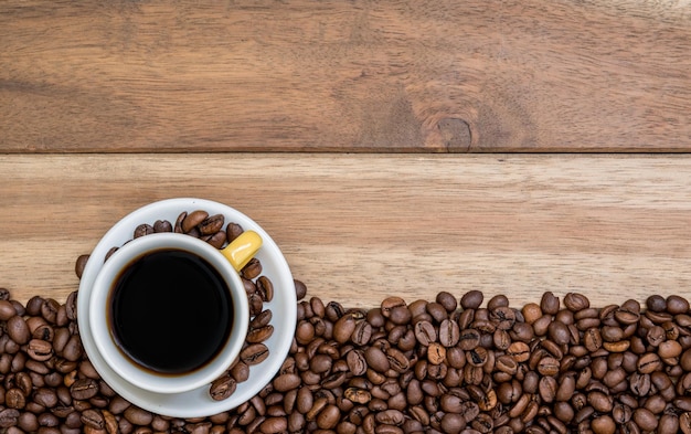 Diretamente acima do tiro de feijão e xícara de café na mesa de madeira