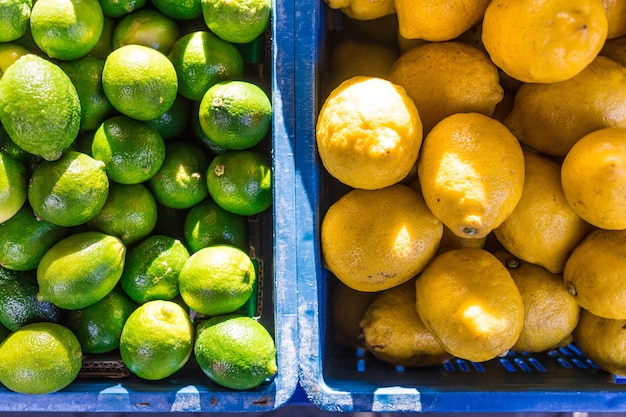 Diretamente acima do tiro de limões verdes e amarelos em caixas no mercado para venda