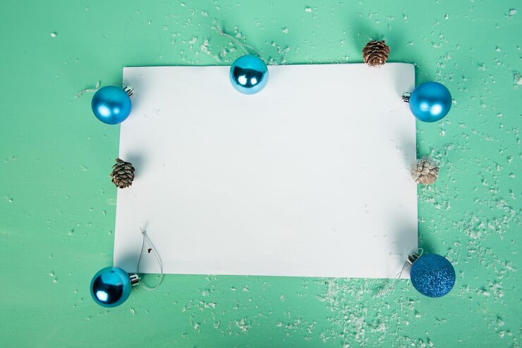 Foto diretamente acima do tiro de papel em branco com decorações de natal sobre fundo verde
