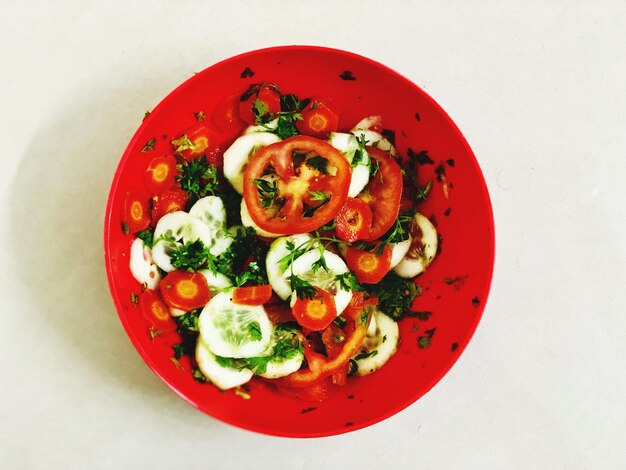 Foto diretamente acima do tiro de salada em prato contra fundo branco