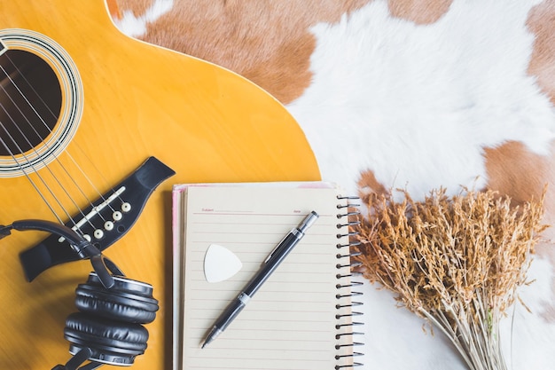 Foto diretamente acima tiro de caneta em livro em branco por guitarra na mesa