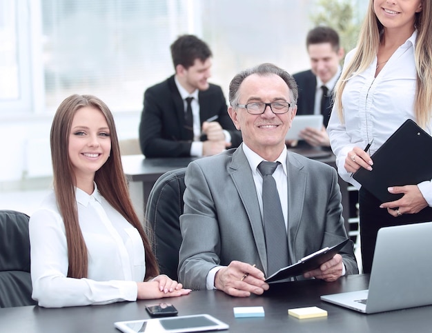 Diretor e assistentes perto da área de trabalho no escritório