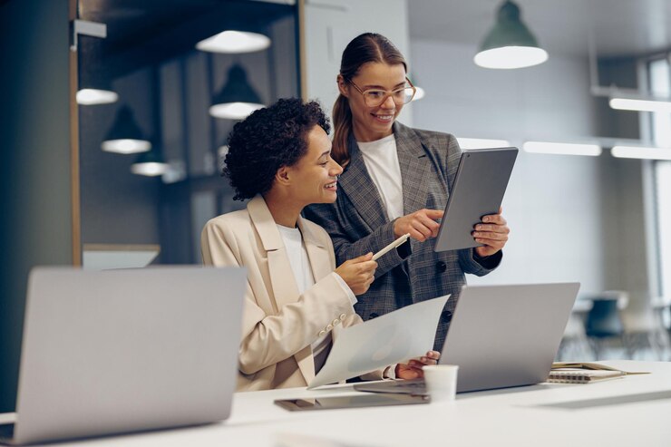 Foto dirigentes femeninas elegantes discutiendo papeles de contabilidad financiera y usando tableta digital