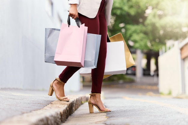 Dirigiéndome a otras tiendas. Captura recortada de una joven irreconocible que cruza la calle mientras sale de compras por la ciudad.