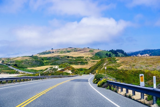 Dirigindo na cênica Rodovia 1 Cabrillo Highway, na costa do Oceano Pacífico, perto das montanhas Davenport Santa Cruz, visíveis ao fundo na área da Baía de São Francisco, Califórnia