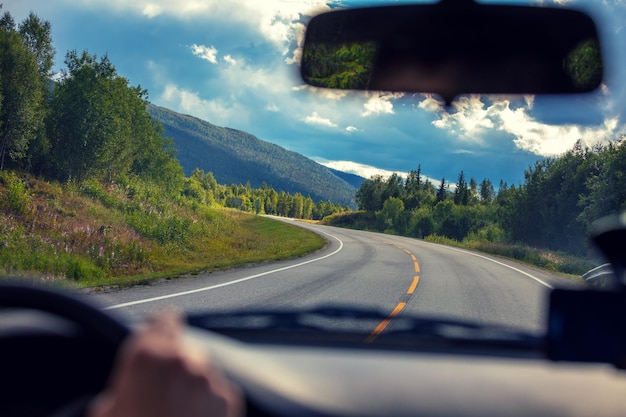 Foto dirigindo um carro em uma estrada de montanha vista do para-brisa da bela natureza da noruega