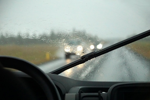 Foto dirigir um carro na chuva com limpadores de para-brisa ativados