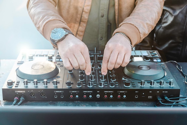 Disc jockey manos tocando música para turistas en la fiesta en la playa al aire libre Evento en vivo música y concepto divertido Entretenimiento y concepto de fiesta