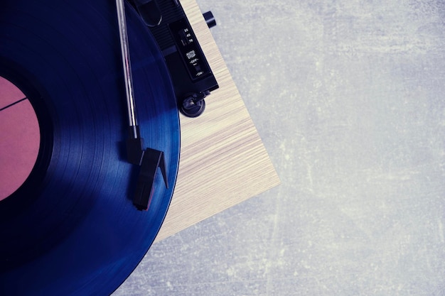 Foto disc player de vinil com disco azul instalado vista de cima fundo cinza