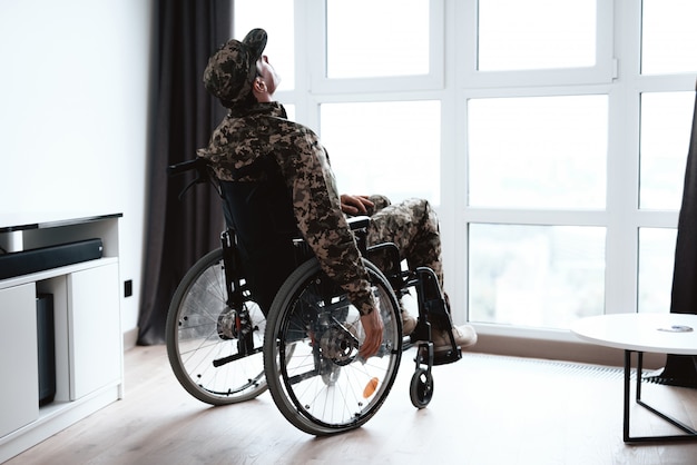 Discapacitados en uniforme militar en silla de ruedas.