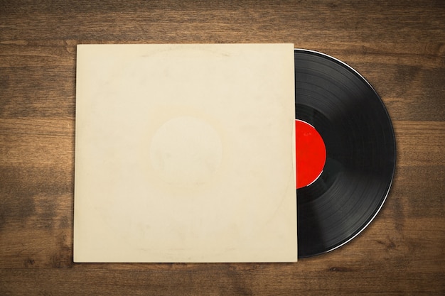 Foto disco de vinil com capa em branco na mesa de madeira