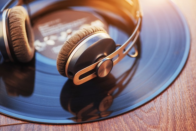 Disco de vinil e fone de ouvido sobre a mesa de madeira