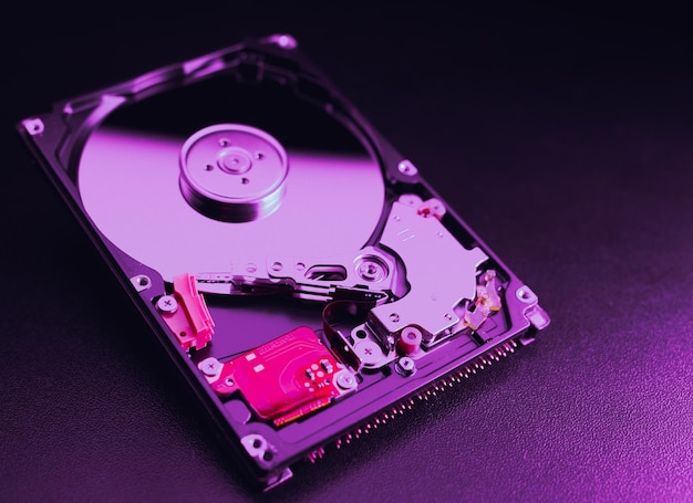 Un disco duro abierto HDD desmontado de una computadora o computadora portátil se encuentra en una superficie púrpura Hardware y accesorios de la computadora Almacenamiento en disco duro