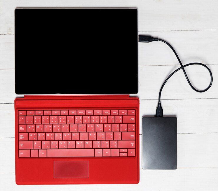 Foto disco duro externo usb en el teclado de la tableta roja