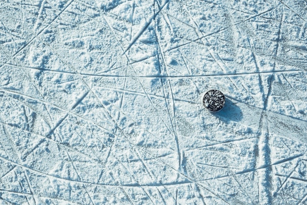 Disco de hockey negro yace sobre hielo en el estadio