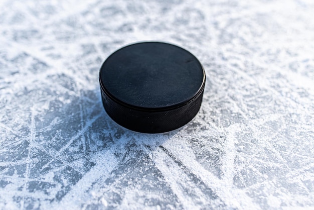 Disco de hockey negro yace sobre hielo en el estadio