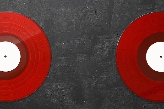 Foto disco de vinilo rojo sobre un fondo de piedra negra estilo retro vista superior