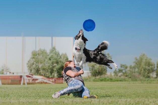 Disco volador para perros. Perro atrapando disco volador en salto, mascota jugando al aire libre en un parque. Evento deportivo, lograr