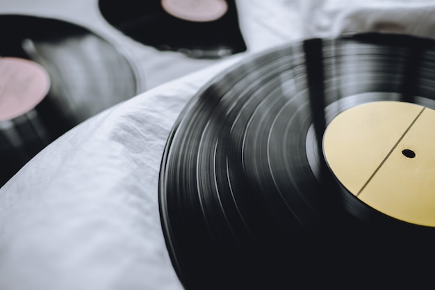 Discos de vinil antigos em uma cama branca.