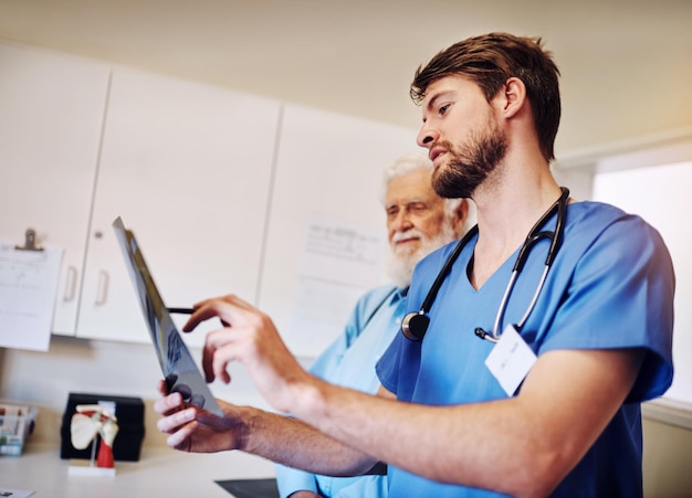 Discussão clínica e enfermeira com raio-X por homem para exame de diagnóstico e avaliação médica Pacientes idosos e cuidados de saúde com varredura radiológica para tratamento ou avaliação de câncer de próstata