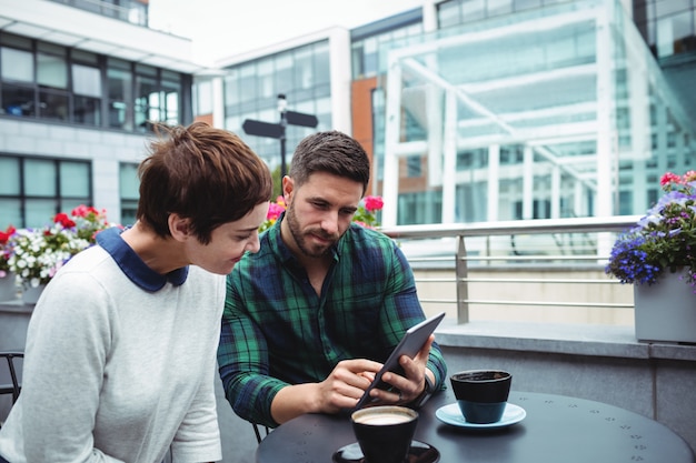 Discussão de empresários sobre tablet digital enquanto tomando café