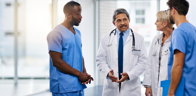 Discutamos las tareas para el turno de hoy. Toma de un equipo de médicos discutiendo en un hospital.