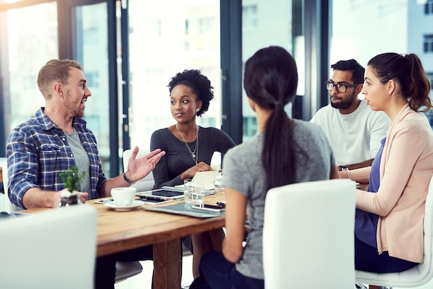 Foto discutiendo el diseño captura recortada de un grupo de colegas trabajando en su oficina