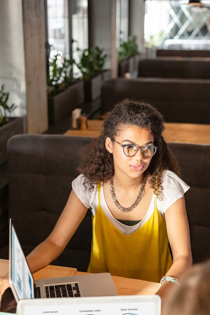 Discutindo questões de trabalho. mulher afro-americana alegre sentada à mesa enquanto conversava com os colegas