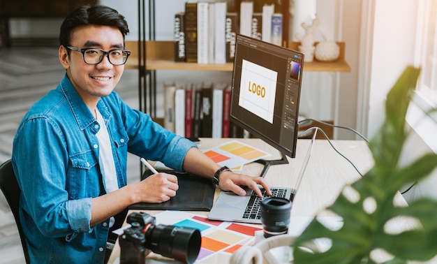 Diseñador asiático joven que trabaja en la oficina