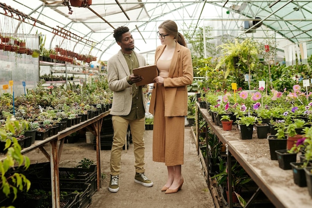 Diseñador con el cliente examinando la lista de plantas.