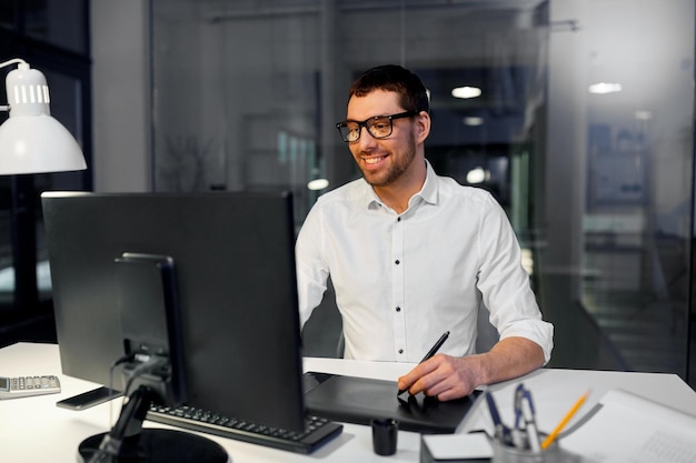 diseñador con computadora y tableta de pluma en la oficina