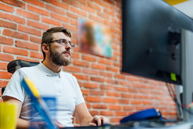 Diseñador creativo joven que trabaja en el negocio de inicio en su oficina