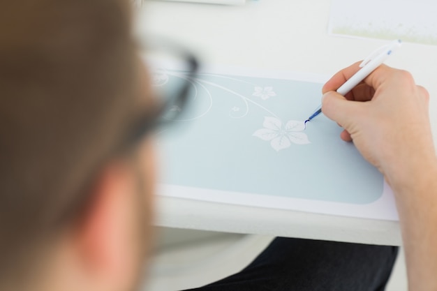 Diseñador dibujando un diseño de flor azul