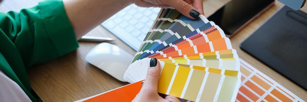 Diseñador eligiendo colores para su futuro proyecto en el estudio de arte cerca del gerente y muchos