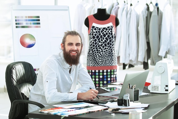 Foto diseñador exitoso trabajando en nuevos bocetos de ropa.