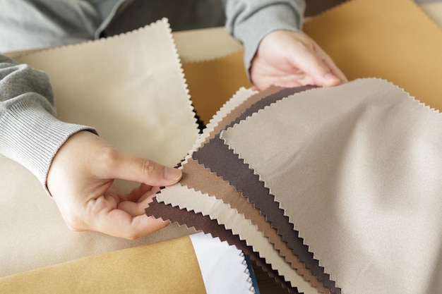 Diseñador femenino con muestras de color de tela eligiendo textiles para cortinas