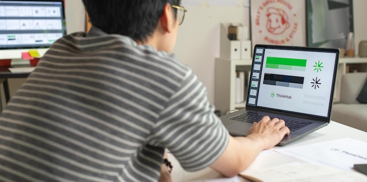 Foto diseñador gráfico asiático que trabaja en un estudio de oficina diseñando logotipos y mostrando la identidad corporativa y el proceso de diseño de logotipos