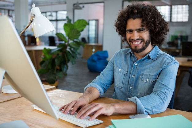 Diseñador gráfico masculino alegre que trabaja en el escritorio