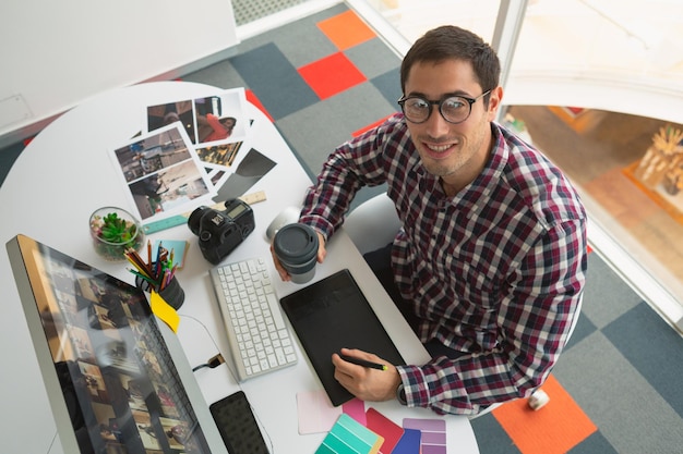 Foto diseñador gráfico masculino trabajando en la computadora en el escritorio de la oficina