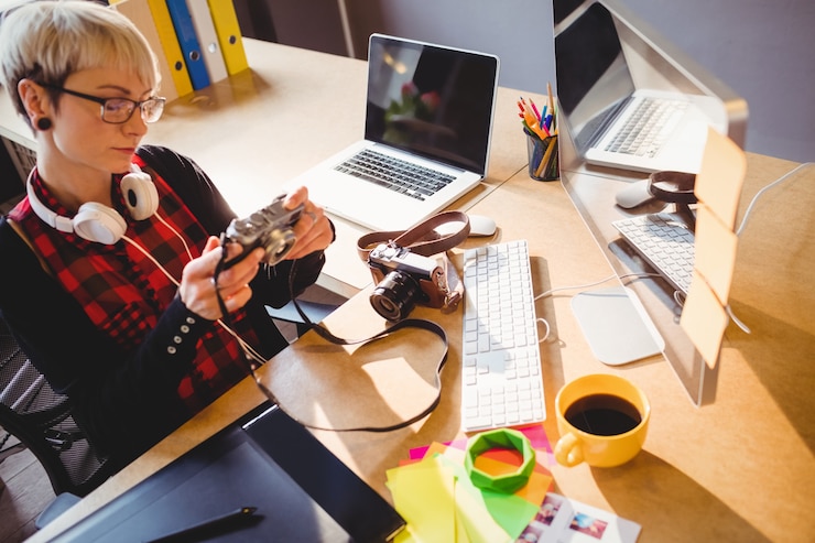 Foto diseñador gráfico mirando fotografías en una cámara digital