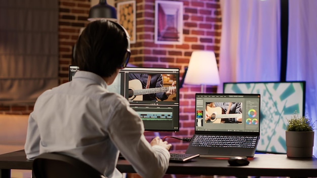 Diseñador gráfico que edita montajes de video en software de producción, trabaja en una computadora para agregar efectos visuales y degradado de color en el metraje. Edite películas multimedia creativas con sonido. .