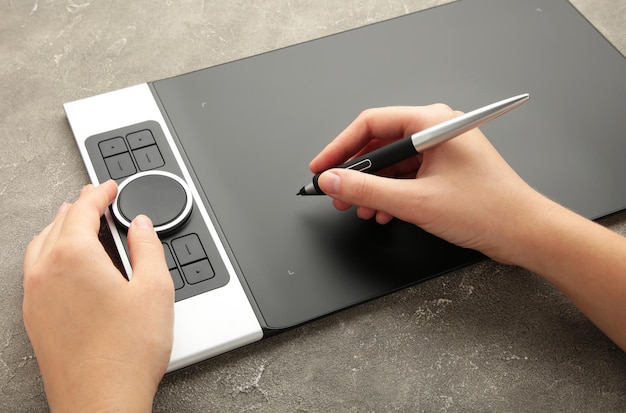 Diseñador gráfico con tableta digital sobre fondo gris