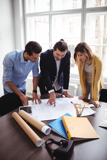 Foto diseñador de interiores con compañeros de trabajo mirando el plano