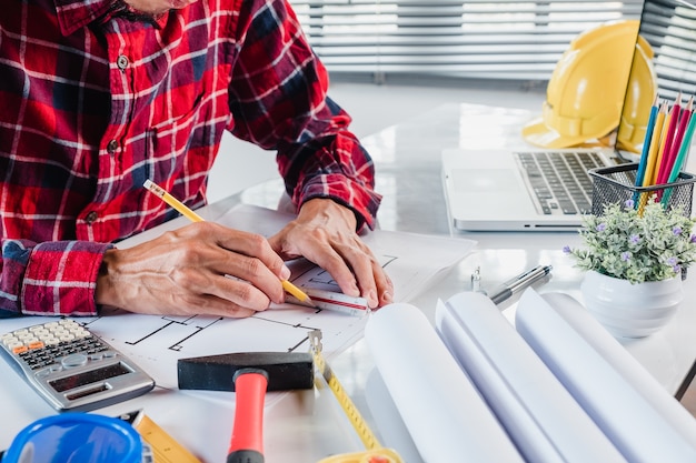 Diseñador de interiores de hombre de negocios trabajando y dibujando con blueprint y proyecto arquitectónico